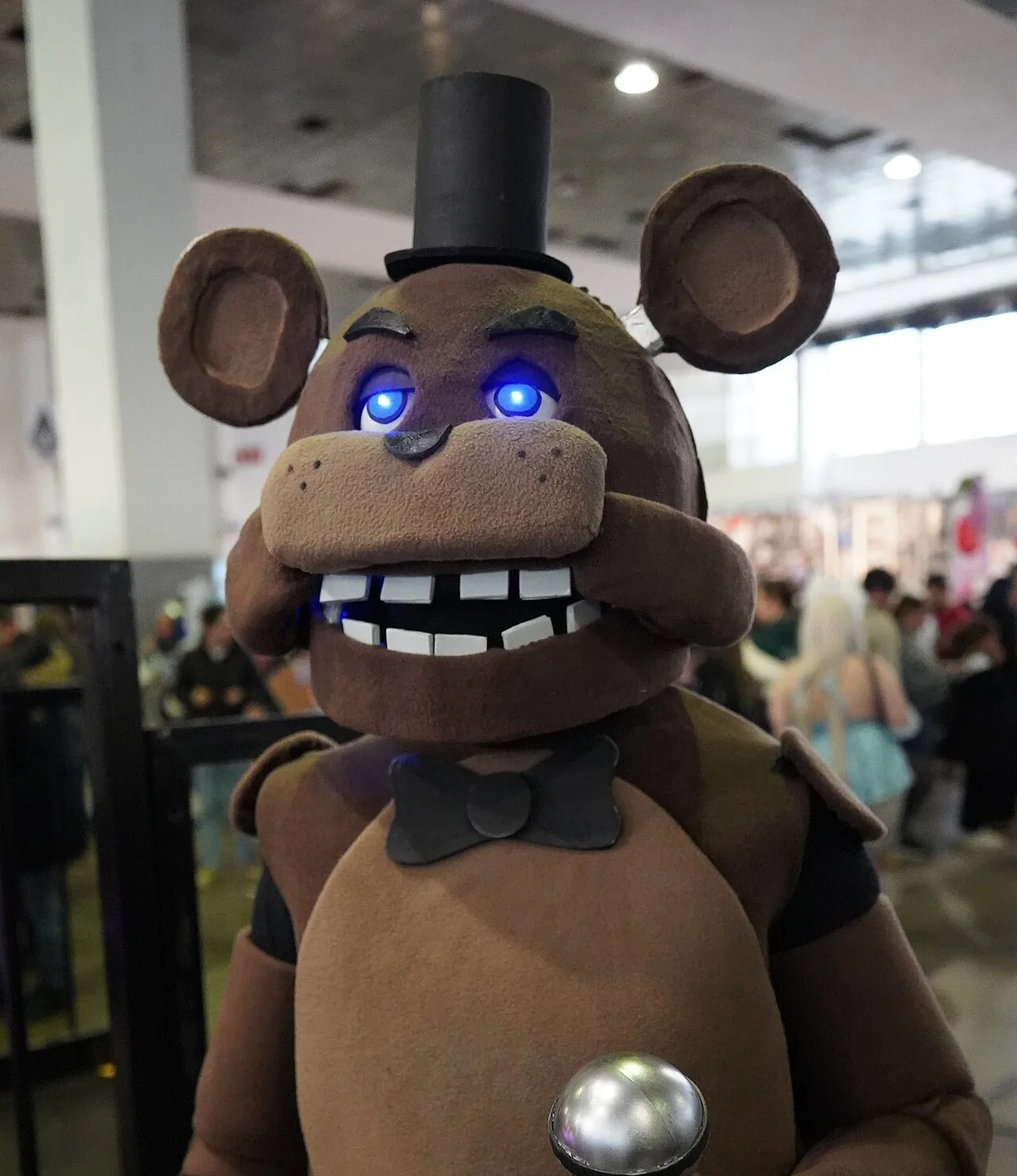 Five Nights at Freddy's: a Freddy Fazbear cosplayer with glowing blue eyes and a microphone at Made in Asia 2024