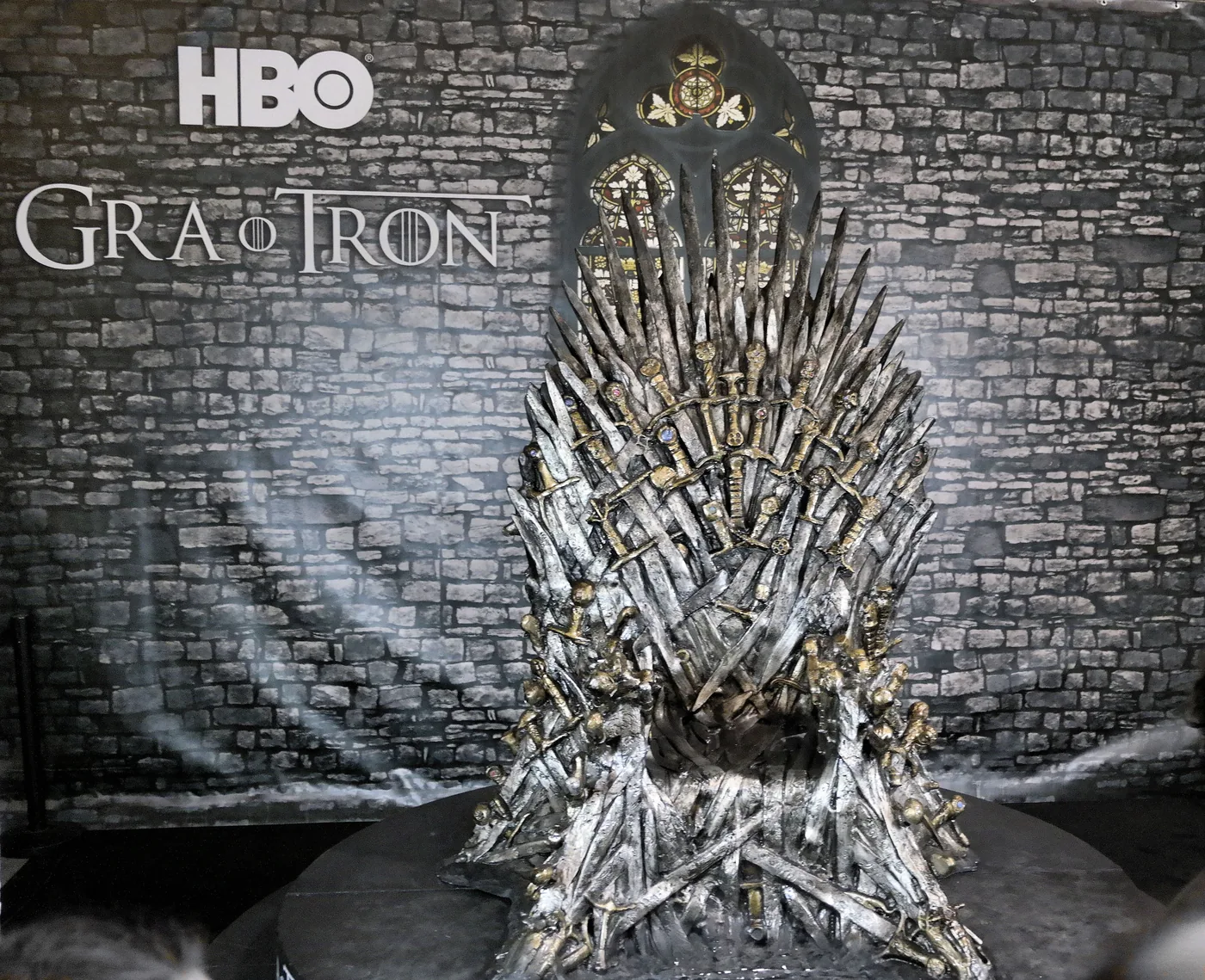 The Iron Throne from Game of Thrones on display against an HBO backdrop