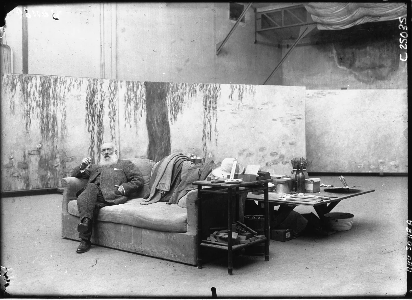 Claude Monet in his Giverny studio in February 1926, standing beside one of the large Water Lilies panels