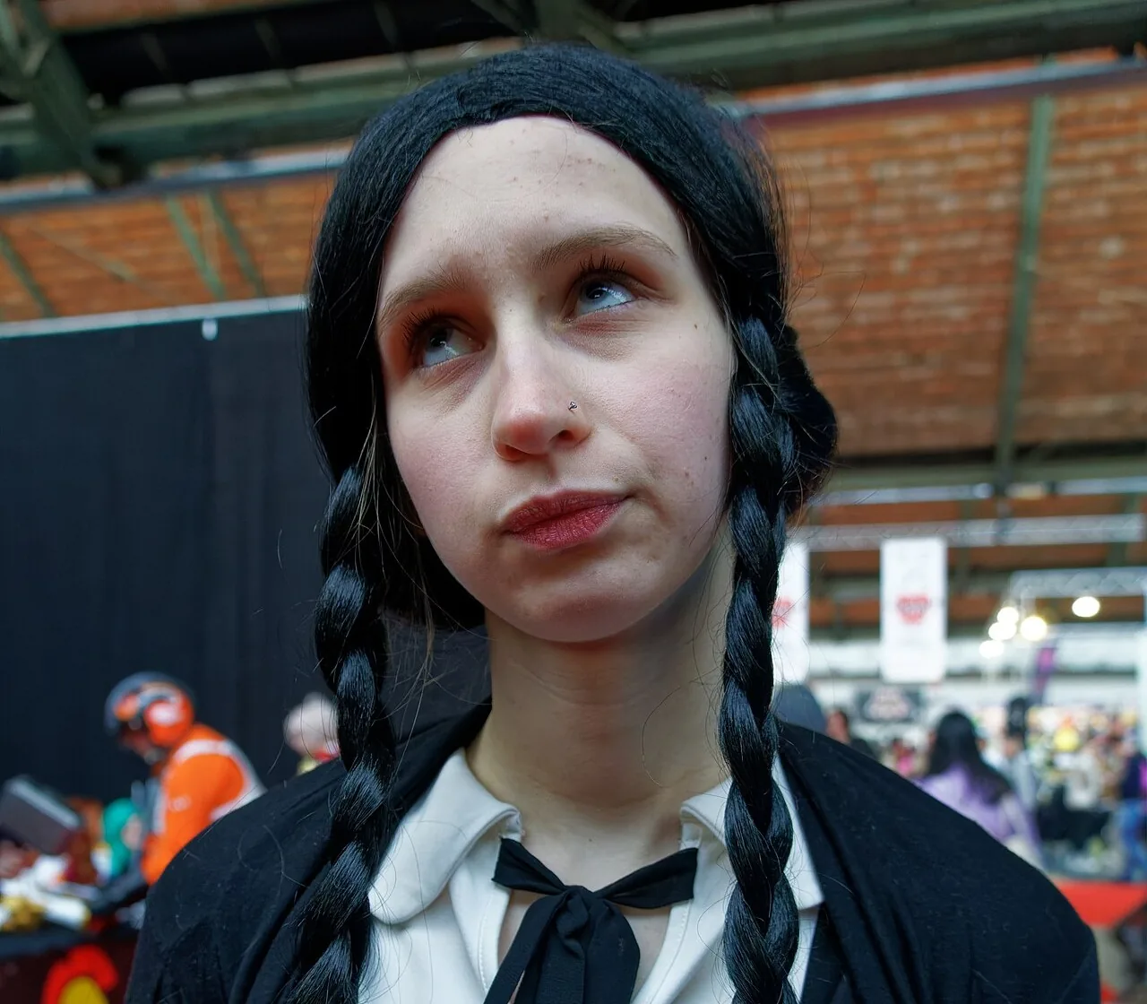 Wednesday Addams cosplay with long black braids and a white collar at Brussels Comic Con 2022